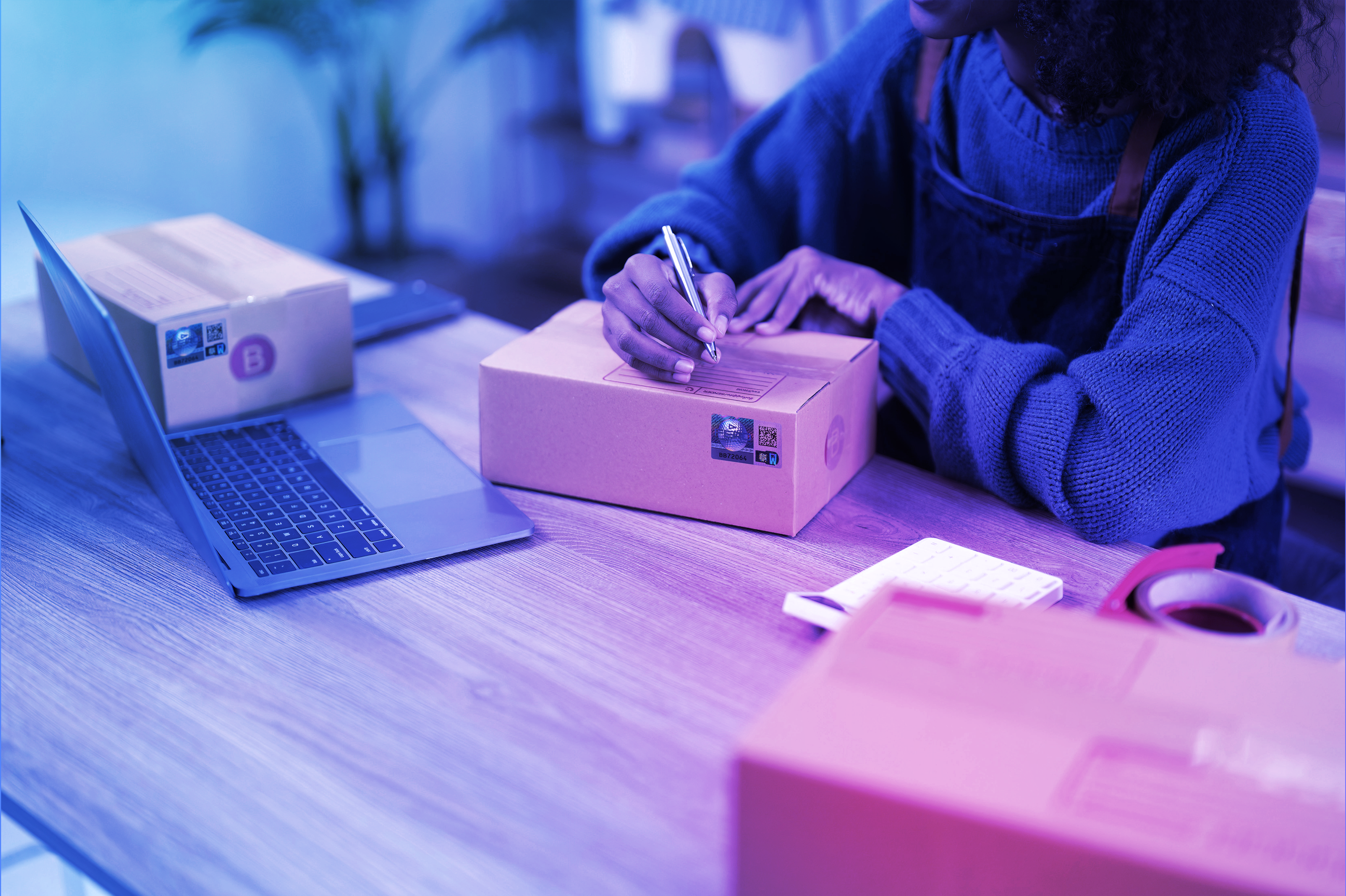 Worker writing a label on a box as part of Crane Authentication product security and tracking process