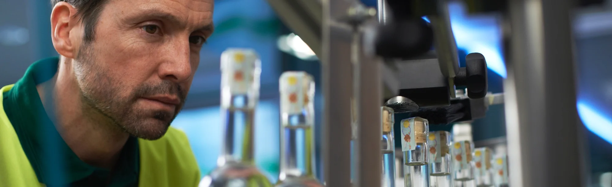 Close-up of alcohol production line worker applying secure GRS Authentication labels