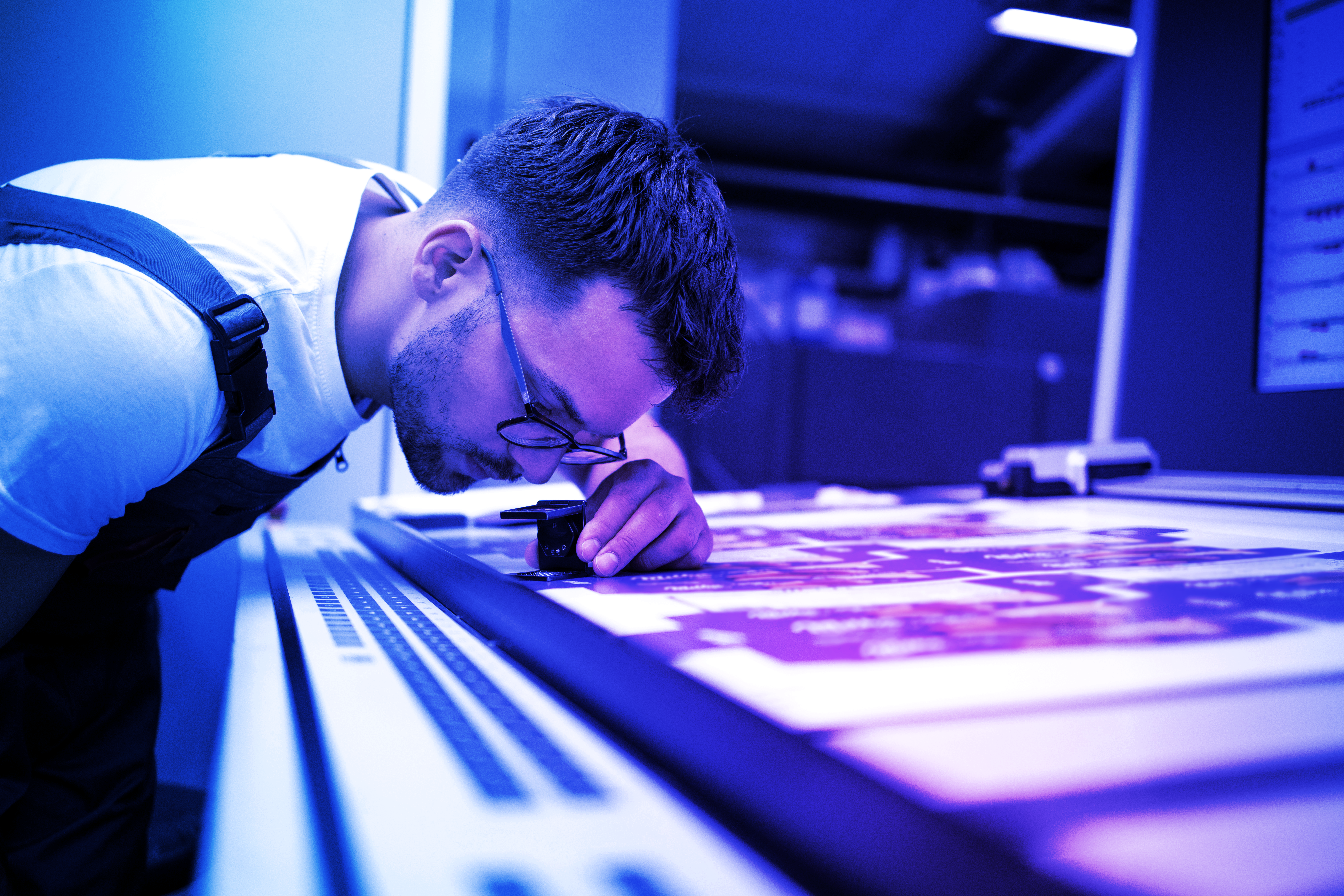 Factory worker examining a product label closely as part of Crane Authentication security verification process